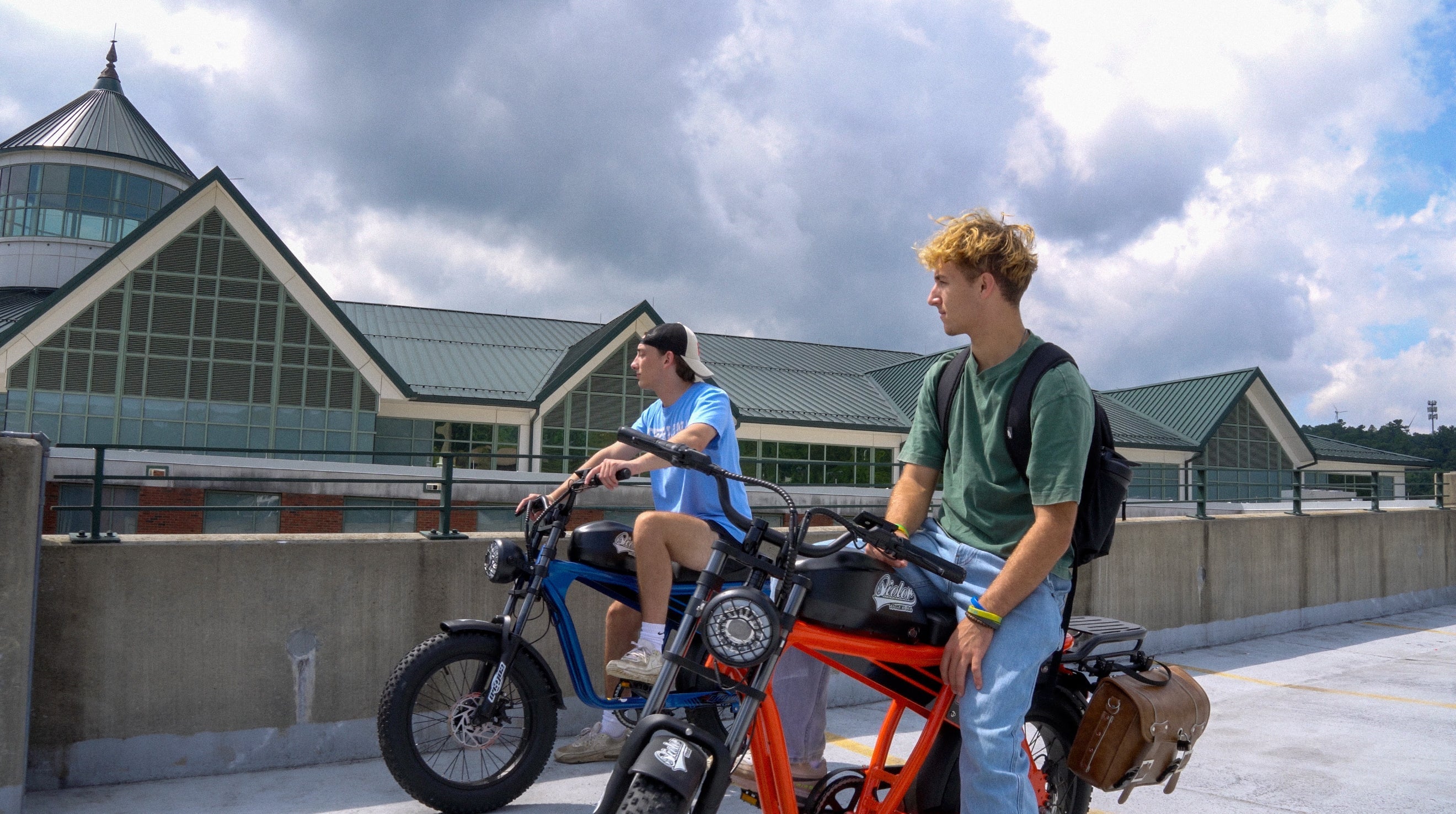 Qiolor Tiger Jr electric bike parked with two riders on a rooftop, featuring a compact retro-style frame and urban setting