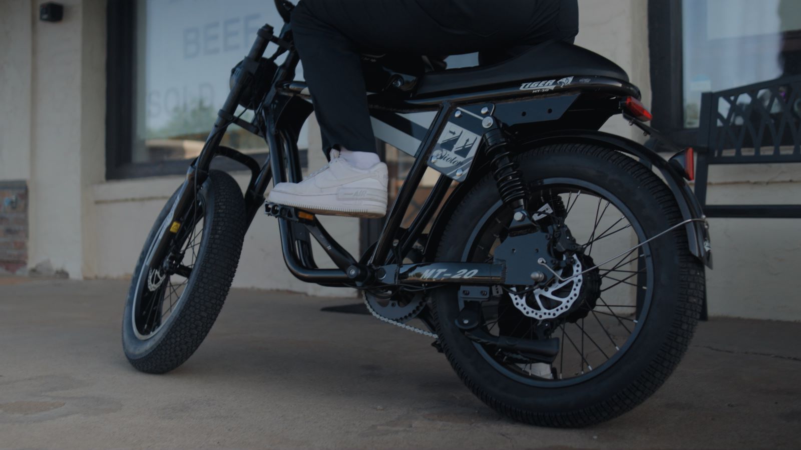 Close-up of electric bike wheel with thick tire, rear suspension, and disc brake system